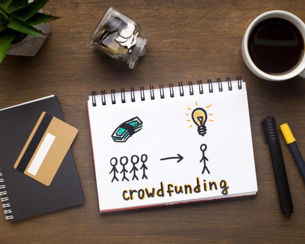 Drawing representing crowdfuning on a desk. 14 Options for Business Capital Funding