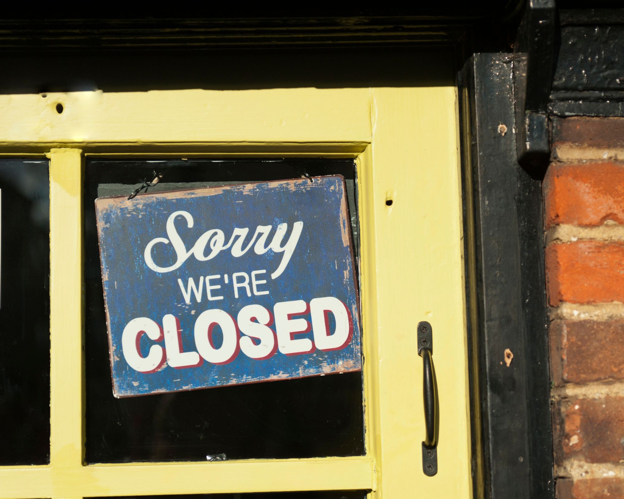 a sign in a window that says sorry we're closed.