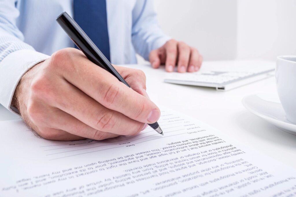 man writing on a legal document
