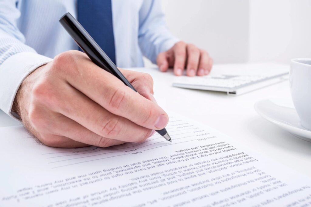 man writing on a legal document