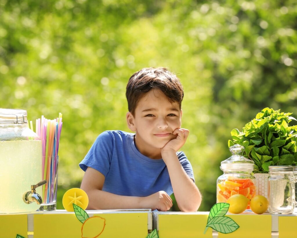 Little boy waiting for his first customer at his lemonade stand.