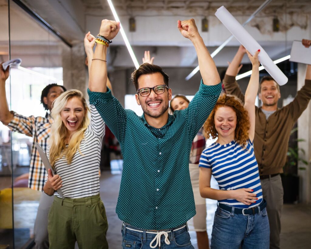 Employees cheering with their hands in the air. Tips for small business employee motivaiton.